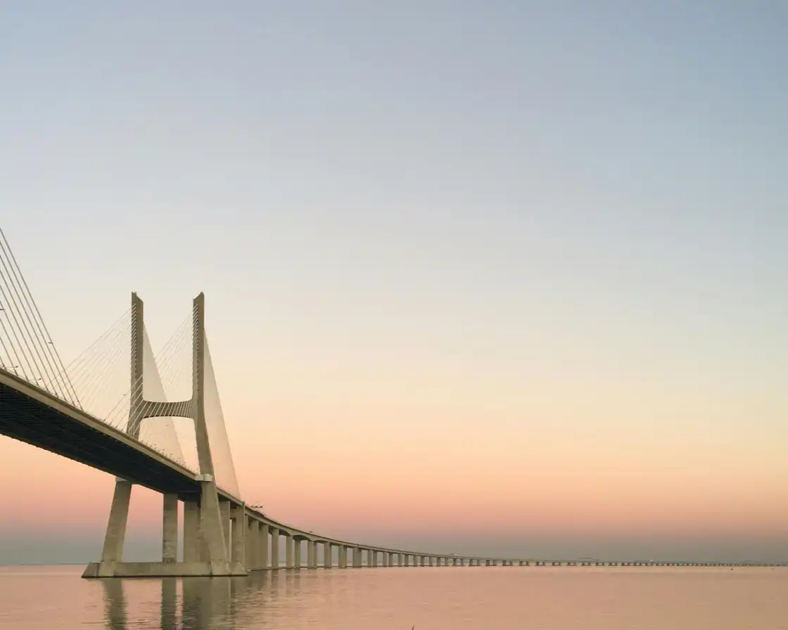The Vasco da Gama bridge crossing the Tagus at dawn under a pale sky