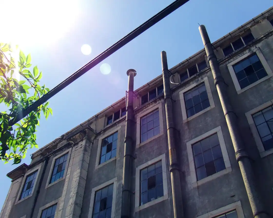 An industrial façade in Alcântara with chimney pipes in hard sunlight