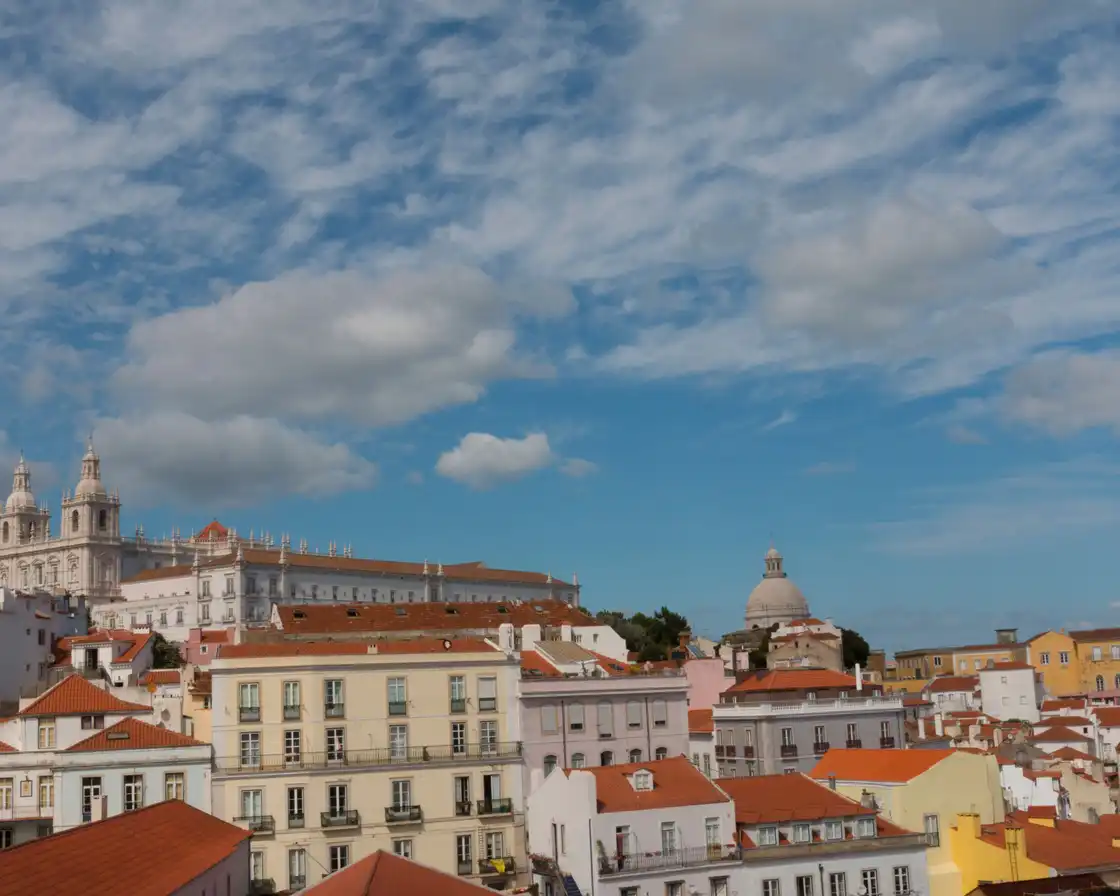 São Vicente de Fora and the National Pantheon above Alfama rooftops under a cloudy sky
